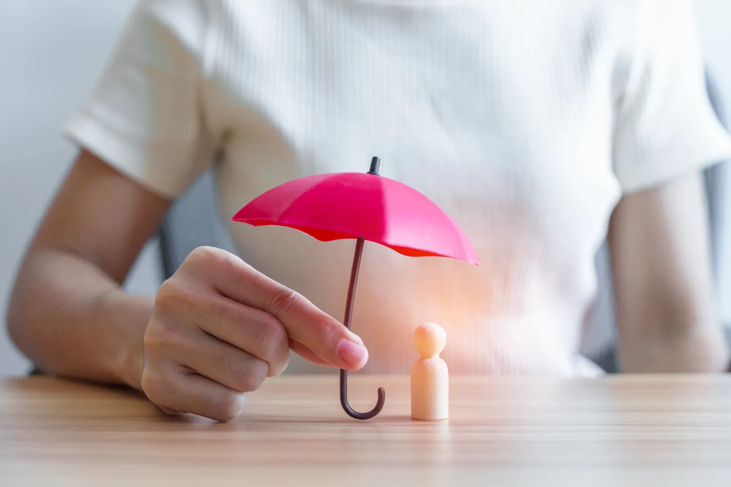 hand holding red umbrella and covering wood man.